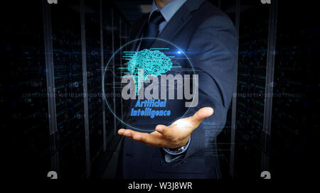 A businessman in a suit and the screen with cybernetic brain hologram. Man using hand on virtual display interface. Artificial intelligence, machine l Stock Photo