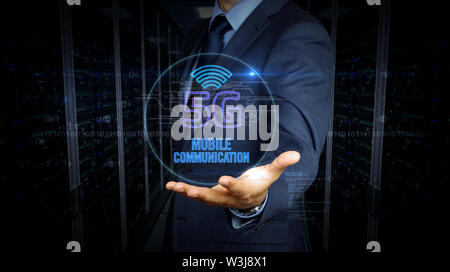 A businessman in a suit and the screen with 5G hologram. Man using hand on virtual display interface. Wireless network, mobile communication, data tra Stock Photo