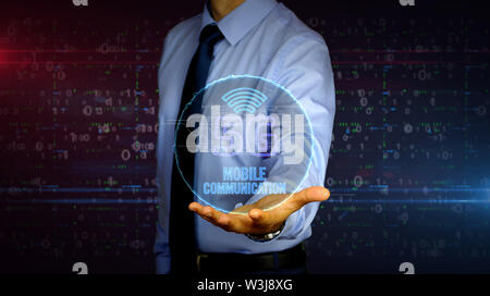 Man with dynamic 5G symbol hologram on hand. Businessman and futuristic concept of mobile wireless network, communication technology, data transmition Stock Photo