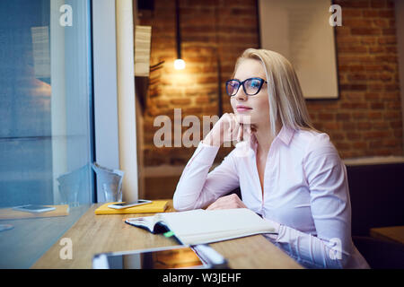 Young businesswoman sitting in cafe taking break from work Stock Photo