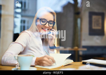 Happy business woman talking on the phone in a cafe during coffee break Stock Photo