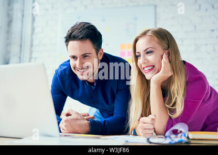 Happy two people collaborationg in office, working together on laptop Stock Photo
