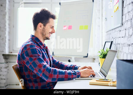 Web designer, hipster working on laptop in office Stock Photo