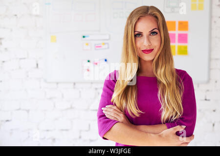 Portrait of female web designer, programmer standing in office Stock Photo