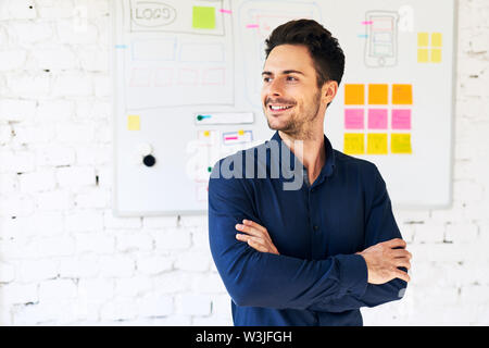 Portrait of happy web designer, programmer standing in office Stock Photo