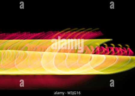 Abstract colorful background. Yellow spirals and red lines on black Stock Photo