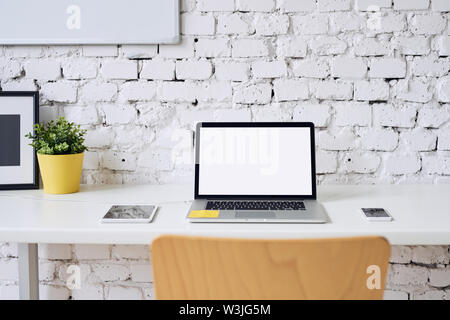 Shot of laptop tablet and phone lying on desk in stylish modern office Stock Photo