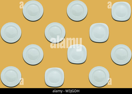 White round plates and four different plates on a yellow flat background. Copy space Stock Photo