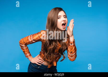 Beautiful young woman in casual clothes shouting loudly. Stock Photo