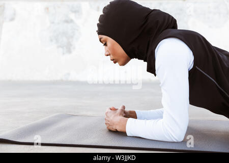 Young Arab woman doing yoga in nature. North African female wearing ...