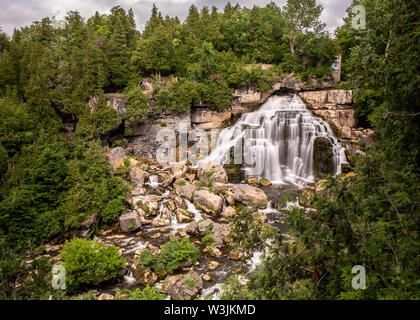 Surrounded by lush green trees, large and beautiful Inglis Falls, near Owen Sound, Ontario, cascades 18 metres down over a rocky cliff. Stock Photo