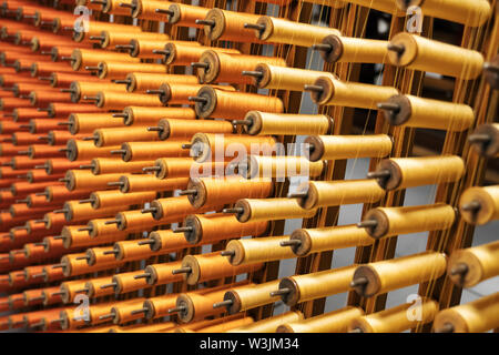 Many multi-colored spool of threads in a sewing factory. Stock Photo