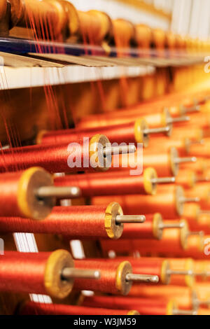 Many multi-colored spool of threads in a sewing factory. Stock Photo