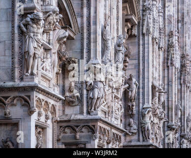 Facade of Duomo Cathedral with details, statues and marble works, Milan, Italy,