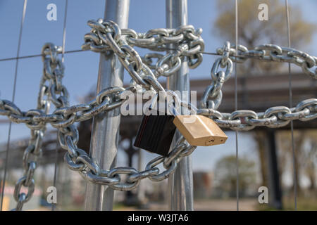steel fence locked with chain and padlocks Stock Photo