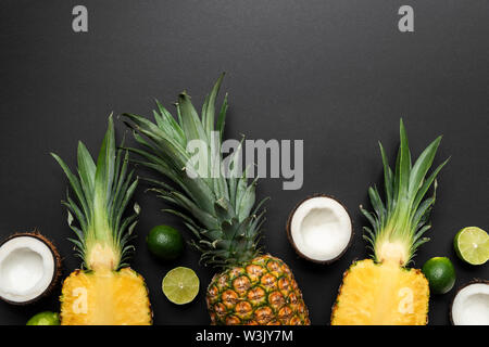 top view of ripe cut and whole coconuts, limes and pineapples on black background Stock Photo