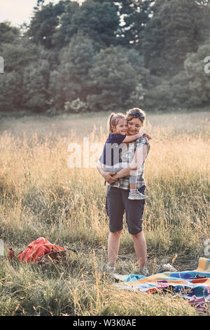 Family spending time together on a meadow, close to nature, parents and children playing together. Candid people, real moments, authentic situations Stock Photo