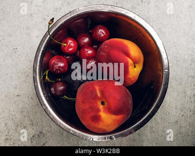 Fresh ripe summer berries and fruits, peaches, apricots, cherry and strawberry in a round plate. Stock Photo