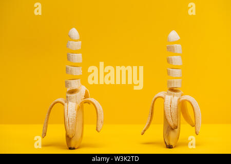 Two freshly sliced delicious bananas isolated on yellow Stock Photo