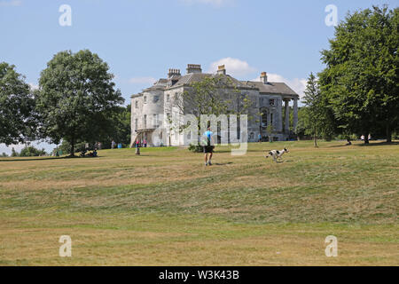 A man walks his dog in Beckenham Place Park, south London, UK. The newly landscaped grounds opened in 2019 return the park to it's original layout. Stock Photo