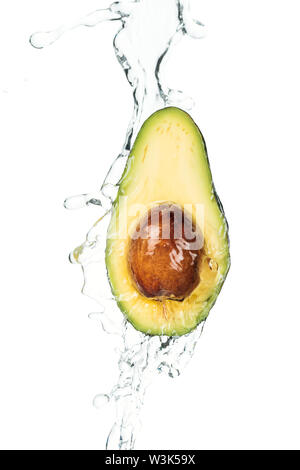 ripe nutritious avocado half with seed and water splash isolated on white Stock Photo