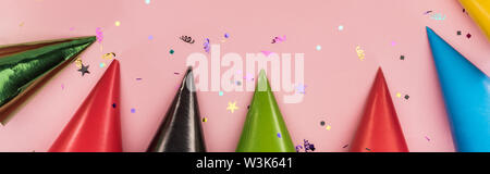 Panoramic shot of multicolored party hats on pink  festive background Stock Photo