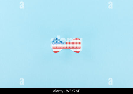 top view of paper cut decorative bow tie made of american flag on blue background Stock Photo
