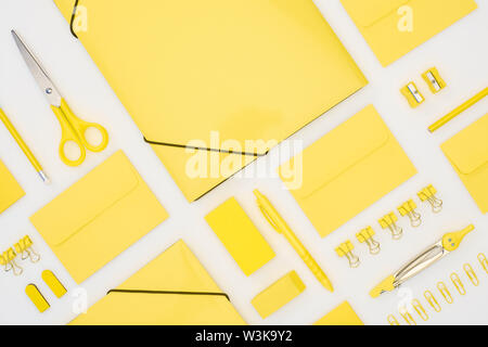 top view of yellow pen, pencils, paper clips, eraser, stickers, envelopes, stickers, folders, scissors, pencil sharpeners and compasses isolated on wh Stock Photo