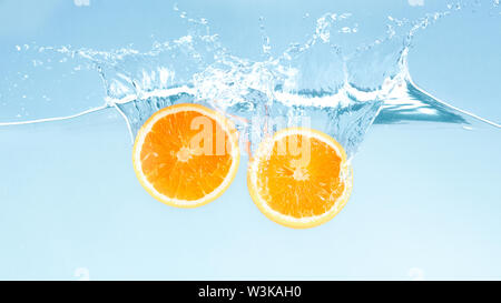 Slices of ripe orange sinking in clear water Stock Photo