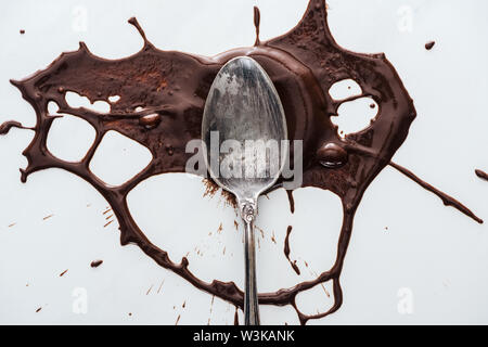 Top view of antique silver spoon with splash of melted chocolate Stock Photo