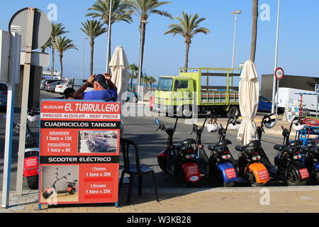 Place of leisure with tandem quadricycles and electric scooter in the Urbanization of Roquetas de Mar of Almería in Spain on july 14, 2019 Stock Photo