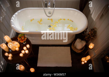 https://l450v.alamy.com/450v/w3km57/rose-petals-scattered-in-a-bath-tub-filled-with-water-and-surrounded-by-candles-w3km57.jpg