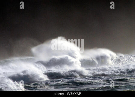 Big waves crashing and spraying water against a very dark, stormy sky in Allan's Beach on the South island of New Zealand. Stock Photo