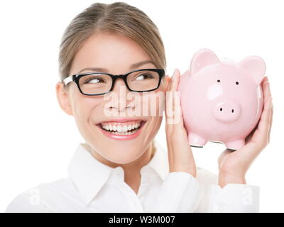 Glasses woman saving on eyewear showing piggy bank smiling happy. Young casual professional business woman holding savings from glasses sale. Young mixed race Caucasian / Asian Chinese female model. Stock Photo