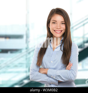 Successful business woman confident portrait. Female businesswoman standing proud and cross-armed looking at camera. Multiracial Asian Chinese / Caucasian female in her 20s. Stock Photo