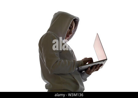 A woman in a hood is using a laptop. Hacker is using a laptop. Stock Photo