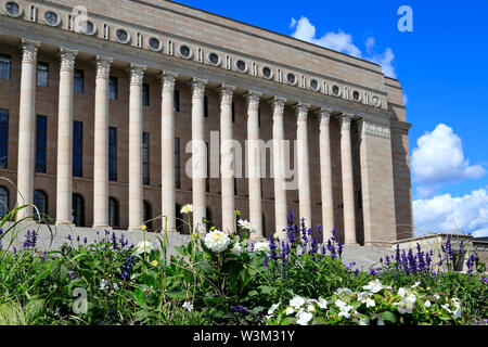 The Parliament House, Helsinki, Finland, designed by Johan Siren and inaugurated 1931, represents Nordic classicism. Selective focus on flowers. Stock Photo
