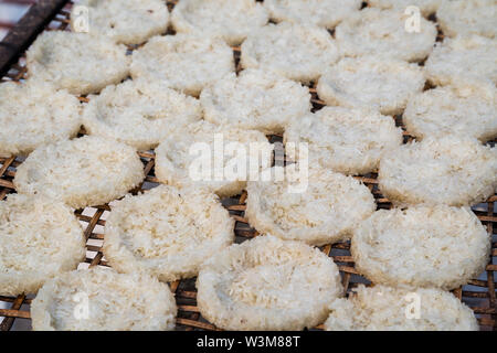 Close-up of sticky rice pressed into round flat cakes drying in the sun on a handmade bamboo tray in Luang Prabang, Laos. Stock Photo