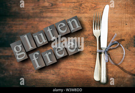 Gluten free menu, healthy eating concept. Gluten-free text and cutlery set on rustic wooden table, top view. 3d illustration Stock Photo