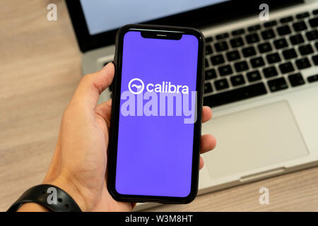 12 July 2019, Ljubljana Slovenia - Hand holding smartphone with Calibra logo on it. Facebook's new global cryptocurrency for transactions Stock Photo