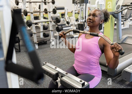 Mature woman weight training in gym Stock Photo