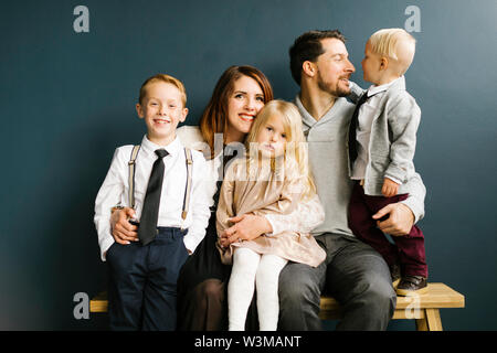 Five children sitting on a bench at the playground and point to ...