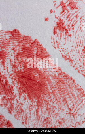Extreme close up of bloody fingerprints on the white paper. Stock Photo