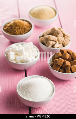 Brown and white sugar on pink table. Stock Photo