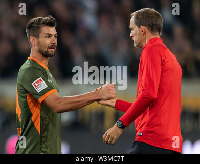 16 July 2019, Saxony, Dresden: Football, test match, SG Dynamo Dresden - Paris Saint-Germain, in the Rudolf-Harbig-Stadium. Paris coach Thomas Tuchel (r) hands over to Dynamos goalkeeper Patrick Wiegers after the match. Photo: Robert Michael/dpa-Zentralbild/dpa Stock Photo