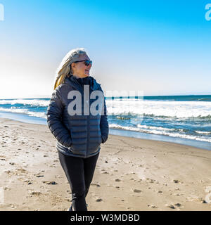 Mature woman walking on beach Stock Photo