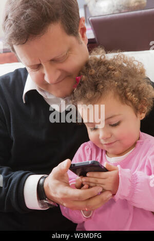 Father and daughter using smart phone Stock Photo