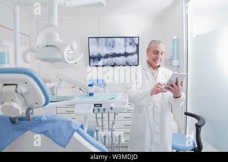 Dentist using digital tablet in dentist's surgery Stock Photo