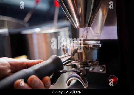 Barista collecting ground coffee in portafilter Stock Photo