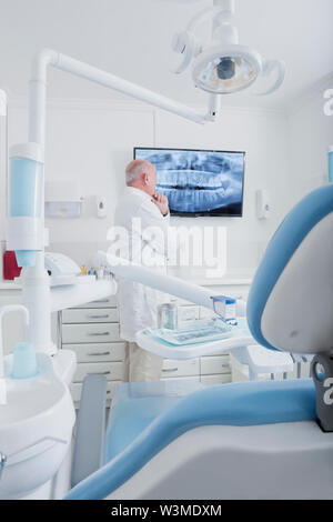 Dentist examining X-ray on television screen Stock Photo